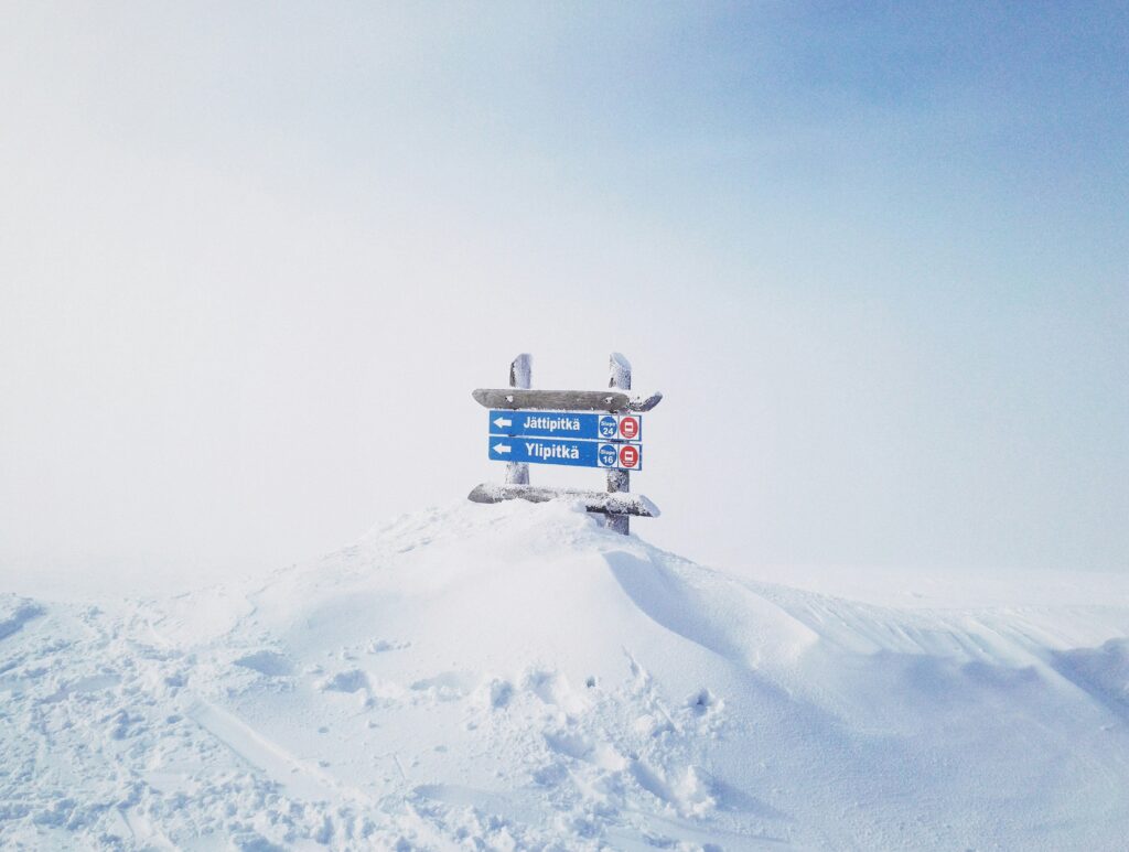 Sneeuw met een board en bord welke richting je in Lapland moet gaan bijvoorbeeld met een sneeuwscooter. 
